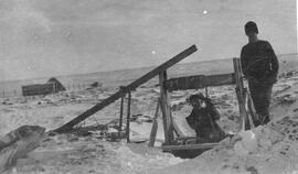 Two men digging a well in winter