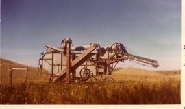 Threshing machine parked in a pasture