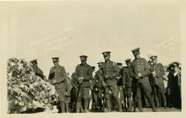 Flower-filled memorial attended by soldiers