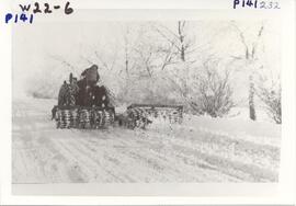 Packing winter snow to make a driveable road.