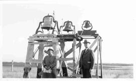 W.C. Murray standing in front of three bells