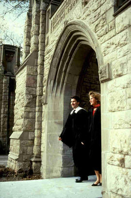 Students in convocation dress walking through Memorial Gates