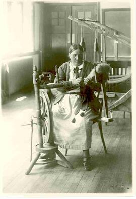 Doukhobor woman at spinning wheel.