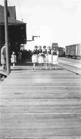 Five Girls on a train platform.